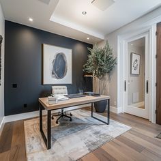 a home office with black walls and wooden floors