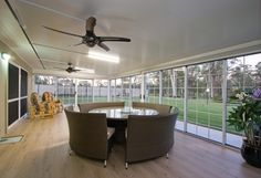 a dining room table with four chairs and a ceiling fan in the middle of it