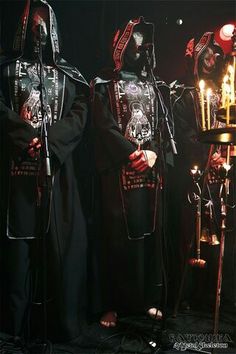 two men in black robes stand next to each other while holding microphones and singing