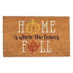 a welcome mat with the words home is where the leaves fall and a pumpkin on it