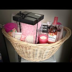 a wicker basket filled with lots of different types of items and candles on top of a table