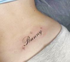 a woman's lower back tattoo with the word bunny written in cursive font