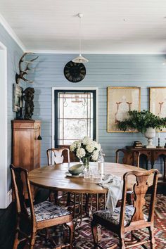 a dining room with blue walls and wooden furniture