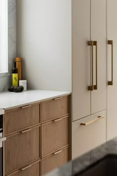 a kitchen with white counter tops and wooden cabinets