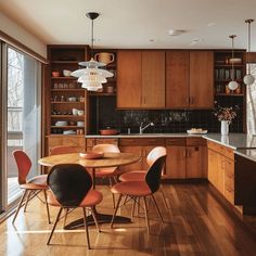 a kitchen filled with lots of wooden cabinets and chairs next to a dining room table