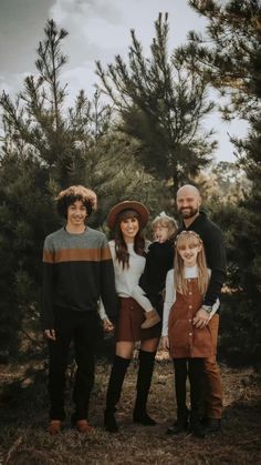 a family posing for a photo in the woods