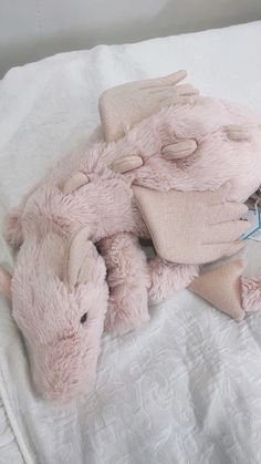 a pink stuffed animal laying on top of a bed