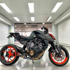 a motorcycle parked in a garage with orange rims