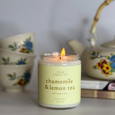 a candle sitting on top of a table next to some tea cups and saucers