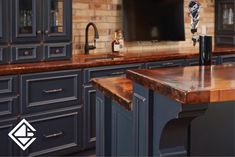 an image of a kitchen setting with blue cabinets and marble counter tops on the island