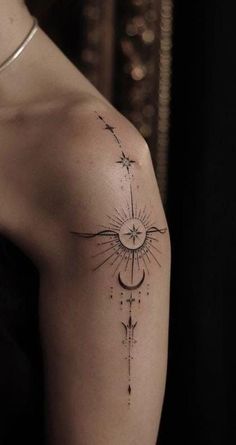 a woman's arm with a sun and stars tattoo on the left side of her shoulder