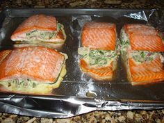 four salmon sandwiches sitting on top of a metal pan