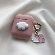 a pink suitcase shaped keychain with a white cloud on it's side