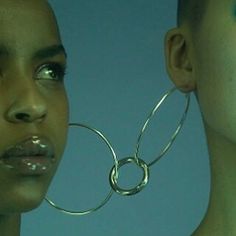 a woman with large metal hoop earrings on her head and another person's face