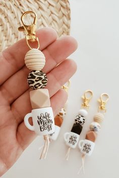 a hand holding a keychain with coffee cups on it