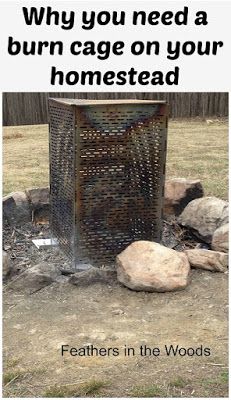 a metal trash can sitting in the middle of a field next to rocks and grass