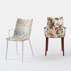 two chairs with floral upholstered fabric on them, one in white and the other in red