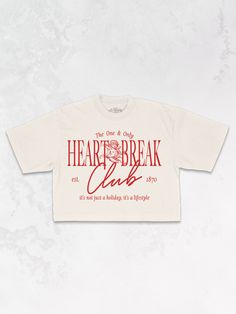 Join the Heart Break Club in our Tennis Club inspired varsity, cropped t-shirt, perfect for Valentine's Day & every day after. - Features the phrase "Heart Break Club" with an angel in the center and the phrase "the one & only" above & "it's not just a holiday, it's a lifestyle" underneath all in a red ink across the front - Screen print transfer that is heat pressed onto each tshirt - Tshirt is a high quality, garment dyed, vintage wash that gets softer after each wash - Regular size fit croppe Tattoo Shop Merch, Varsity Shirt Design, Club Tshirt Designs, Tour Tshirt Design, Street Wear Tshirt Design, Oversized Cropped Tshirt, Cool Tshirt Designs, Screen Print Designs, Unique T Shirts