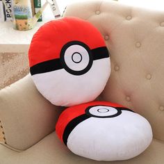 two pokemon stuffed animals sitting on top of a couch next to each other in front of a window