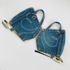 two purses made out of old jeans are sitting on a white surface with scissors