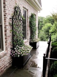 a brick house with two planters on the front porch