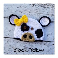 a crocheted cow hat with a yellow bow on it's head and ears