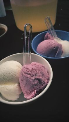 two bowls filled with ice cream on top of a black table next to each other