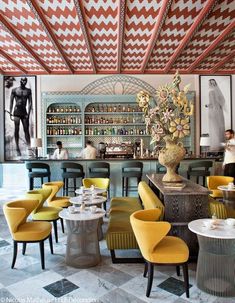 the inside of a restaurant with yellow chairs and checkered flooring on the walls