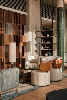 a living room filled with furniture next to a tall wooden book shelf on top of a hard wood floor