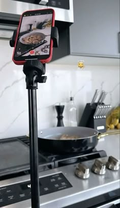 a tripod mounted to the side of a stove with food on it's plate