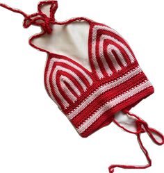 a red and white crocheted hat on a string