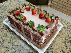 a chocolate cake topped with strawberries on top of a counter