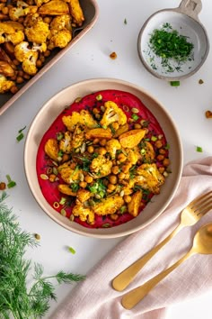 a bowl filled with some kind of food on top of a white table next to other dishes