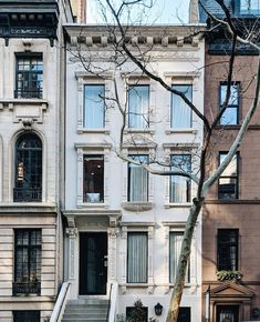 an apartment building with stairs leading up to the front door and windows on both sides