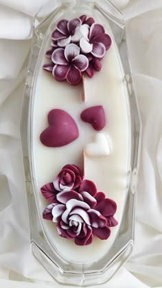 a candle with flowers and hearts on it