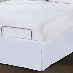 the bed is made with white sheets and pillows