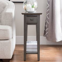 a small table with a glass ball on it next to a couch and a chair