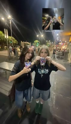 two women standing next to each other holding cups