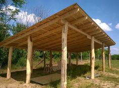 a wooden structure sitting in the middle of a field