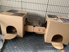 two cardboard boxes that are sitting on the floor in front of a caged animal