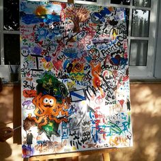 an easel is covered with graffiti and stickers