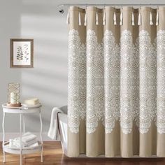 a shower curtain with white lace on it in a bathroom next to a bathtub