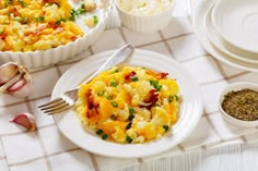 a white plate topped with macaroni and cheese on top of a table next to other dishes