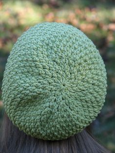 the back of a woman's head wearing a green knitted hat