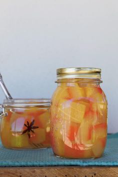 two jars filled with fruit sitting on top of a table