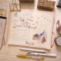 the contents of a planner spread out on a table with pens, tape and other items