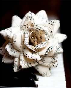 an image of music is life written with sheet music and a rose on piano keys