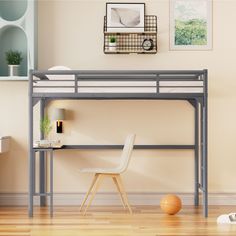 a loft bed with a desk underneath it in a room that has hard wood floors