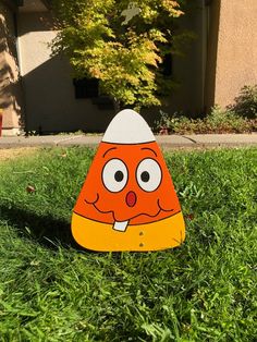 an orange and white cone sitting in the grass