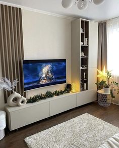 a flat screen tv sitting on top of a white entertainment center in a living room